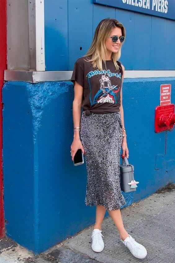 Chica con falda de brillos y camiseta con print en negro.