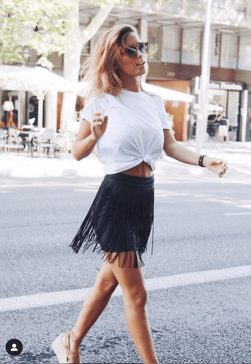 Look de falda de flecos con camiseta blanca