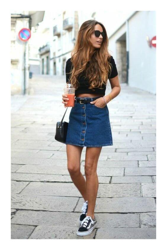 Chica con minifalda en A vaquera y camiseta negra.