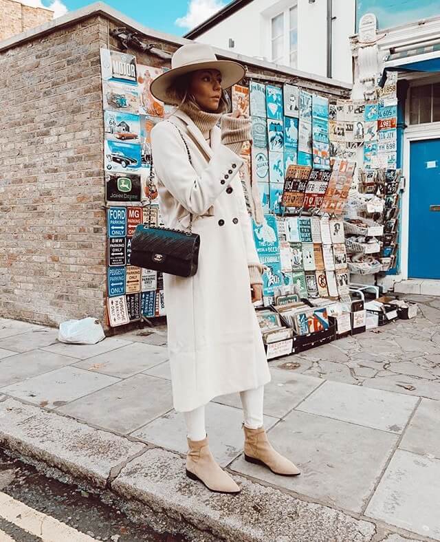 Influencer Aretha Fusté con abrigo largo blanco.
