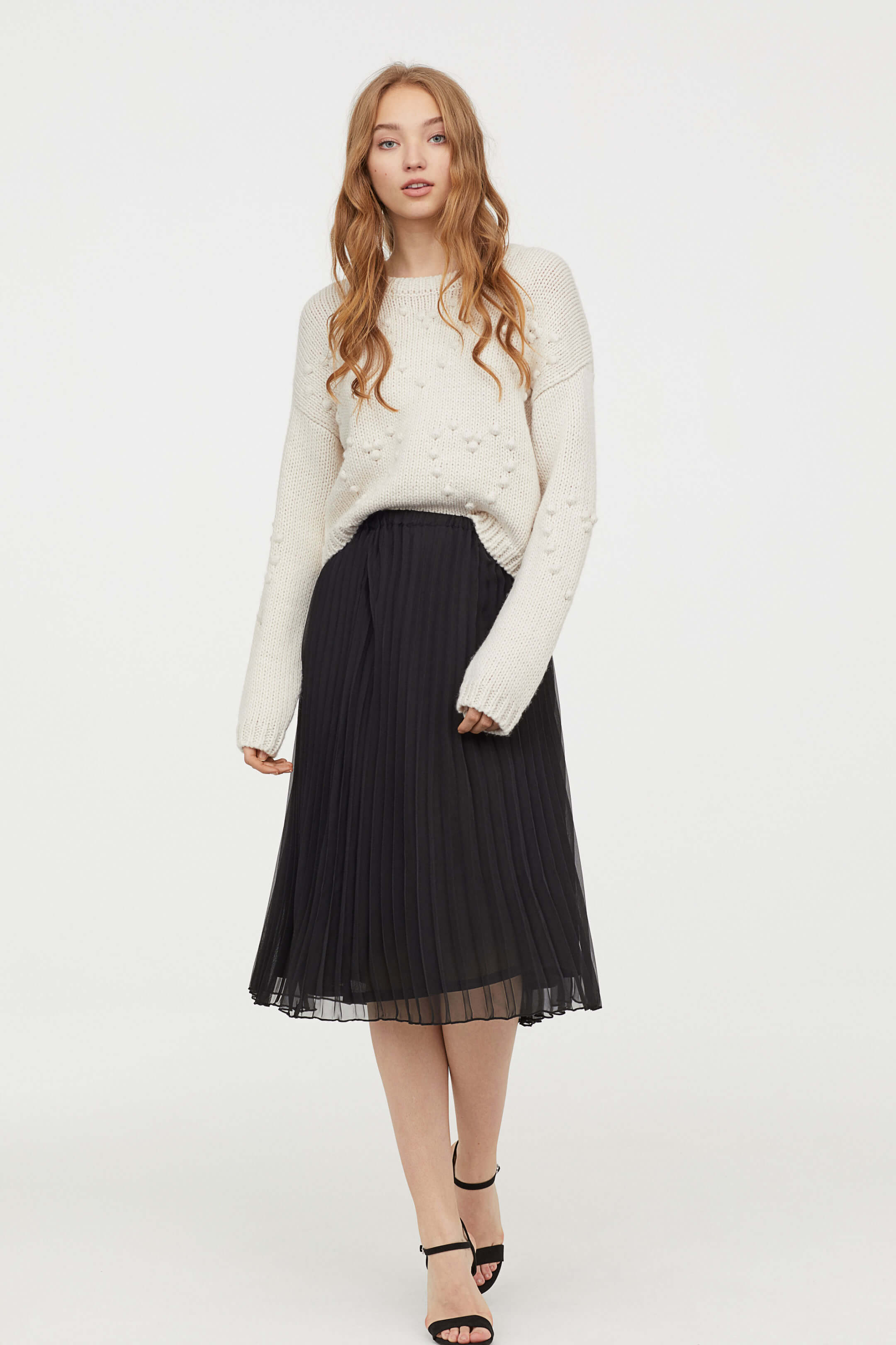 Falda acordeón en color negro a media pierna de H&M.