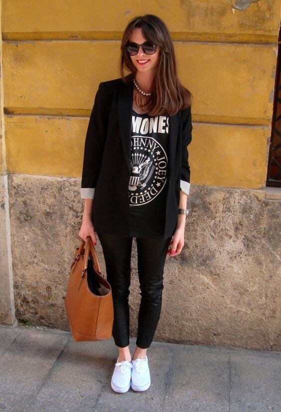 Look de vaqueros negros, camiseta estampada, blazer negro y zapatillas blancas.