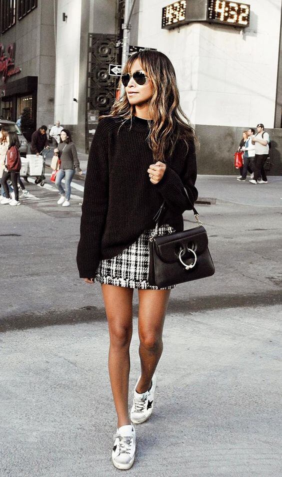 Look casual de jersey negro con falda corta.