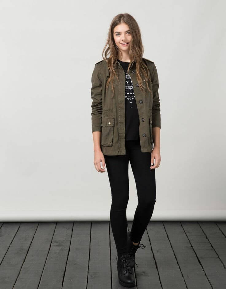 Chaqueta verde militar en un conjunto de prendas negras.