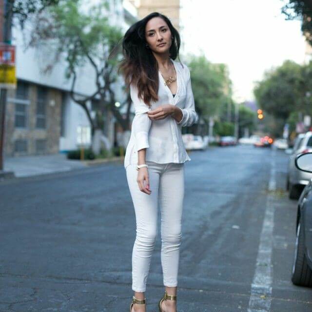 Outfit de blusa y pantalón blanco con accesorios dorados.