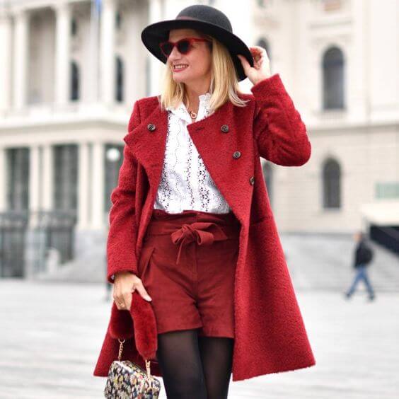 Chica con pantalones cortos y saco en color rojo.