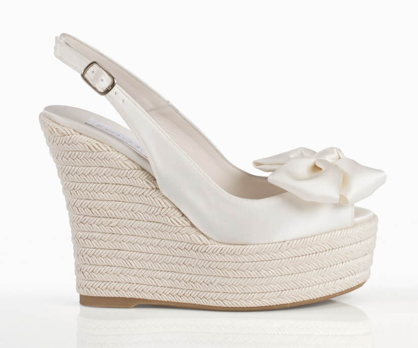 Alpargatas blancas con lazo al frente y dedos al descubierto.