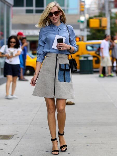 chica en la calle con camisa azul y falda gris en evasé