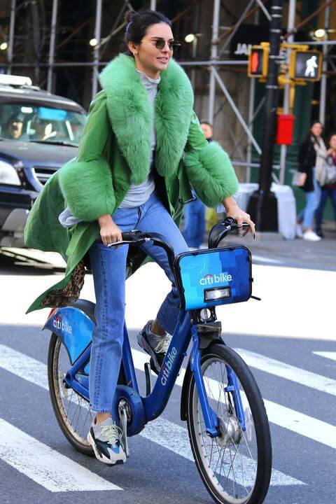 kendall jenner en bicicleta con abrigo de pelo verde y jeans