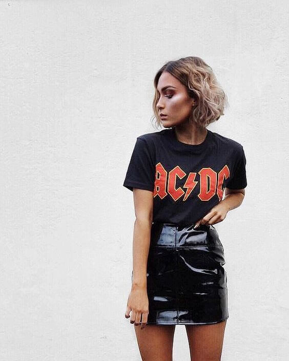 Mujer con camiseta estampada y falda de cuero.