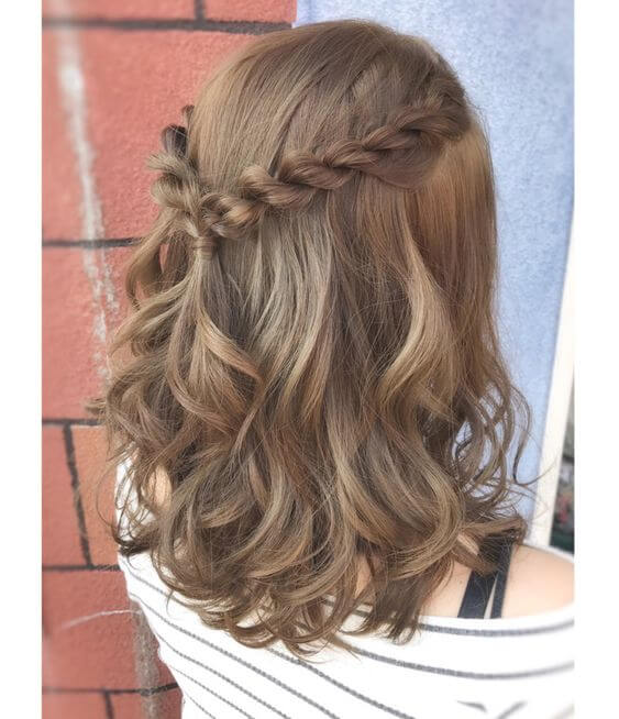 Chica con el cabello corto con un semirecogido de trenzas.